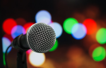 Fototapeta na wymiar Microphone on abstract blurred of speech in seminar room or speaking conference hall, Event bokeh light Background