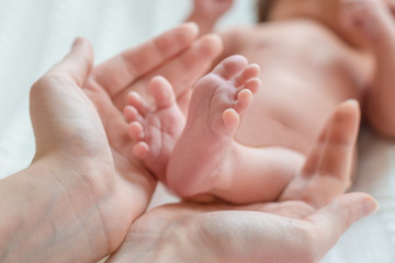 Obraz na płótnie Canvas Baby feet in mother hands