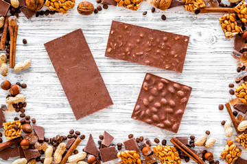 Chocolate bars of different varietes on grey wooden background top view