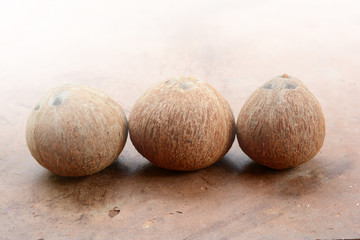 three brown coconut ripped on cement background
