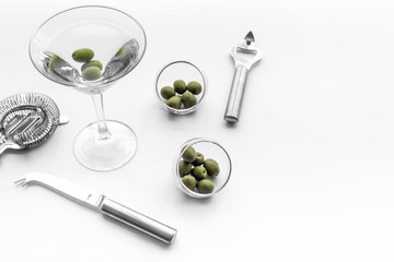 Martini cocktail in glass with olives at the bottom on white background top view copyspace