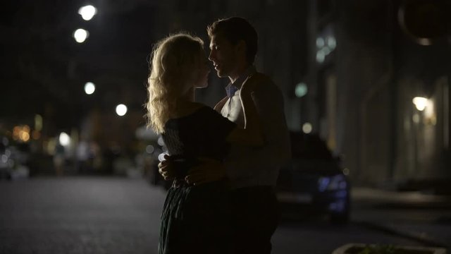 Couple of lovers dancing in empty night street, dating and love, seduction