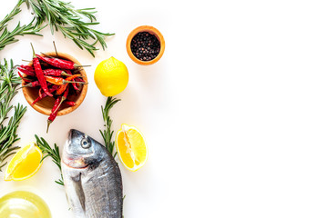 Preparing dorado with spices rosemary, pepper, chili, lemon. White background top view copyspace