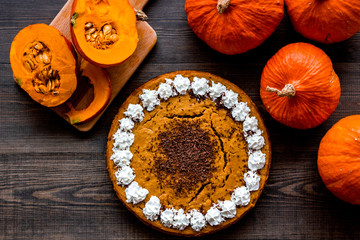 Pumpkin pie for thanksgiving day on dark wooden background top view