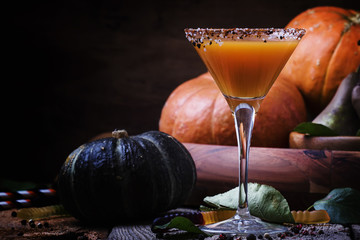 Halloween orange cocktail on a dark festive autumn background, selective focus and shallow DOF