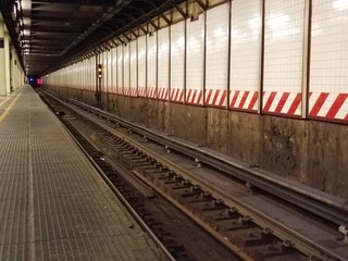 Obraz premium Underground subway platform with train tracks in a tunnel