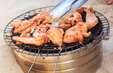 Person Prepares Chicken Wings on Barbecue Grating on Beach