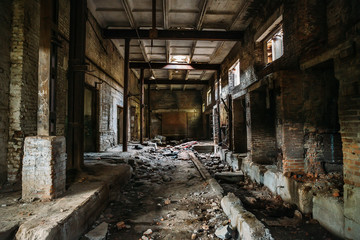 Dark scary corridor in abandoned industrial ruined brick factory, creepy interior, perspective
