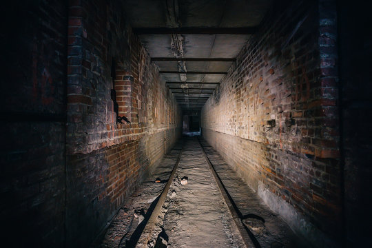 Dark scary corridor in abandoned industrial ruined brick factory, creepy interior