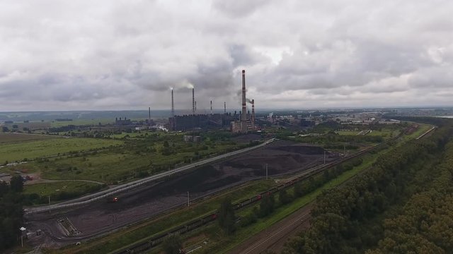 Approaching the territory of concentrator: industrial pipes, industrial landscape. Coal section: general view of mine enterprise. Industry, extraction of minerals, mine. Power plant, coal mine, aerial