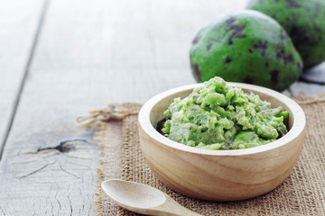 Grated avocado and green on wooden.