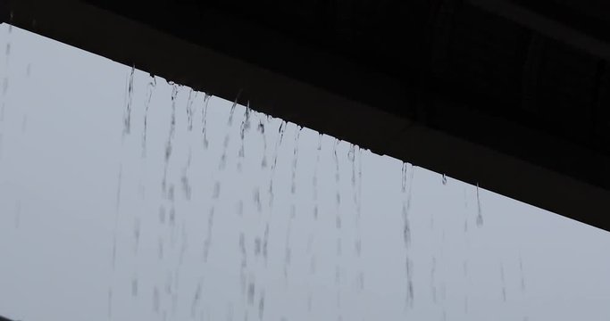 water rain drops overflow on gutter roof house, rainy day weather scene