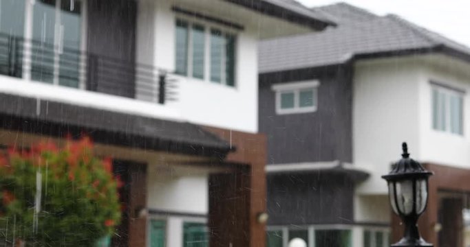 rainy day scene, focus rain falling in sky with blur house background