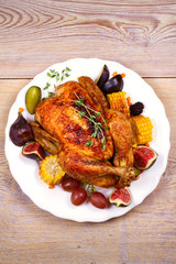 Chicken with figs, corn on cob, grape, plums and blackberry, overhead