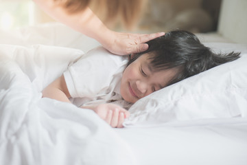 Obraz na płótnie Canvas Asian child sleeping on white bed