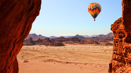 Naklejka premium Colorful hot air balloon flight in the blue sky in beautiful landscape of multicolored stony desert with rocks. Timna geological park. Israel