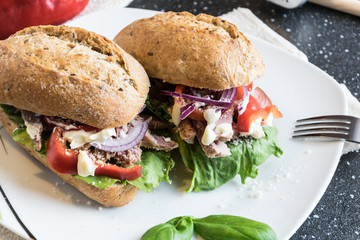 Homemade sandwich with pieces of grilled pork, vegetables and mayonnaise