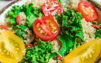 Colorful photo of a quinoa, goji berry, and kale vegetable salad in a bowl against white background. Healthy food, eating, fitness, diet, vegan, vegetarian, and superfood concept.