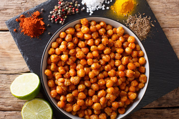 Spicy Roasted chickpeas in a bowl and ingredients close-up. horizontal top view