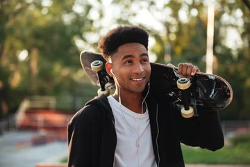 Afwasbaar fotobehang Young happy skateboarder man holding skateboard © Drobot Dean