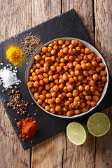 Spicy Roasted chickpeas in a bowl and ingredients close-up. Vertical top view