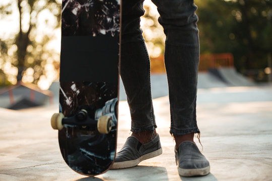Cropped image of an african man skateboarder standing