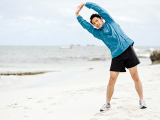 Young man doing exercise at the beach