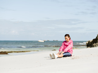 Naklejka na ściany i meble Young woman at the beach doing exercises