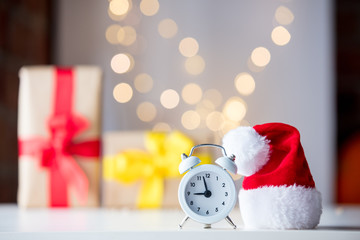 Vintage Alarm clock in Santa Claus hat with Christmas gift