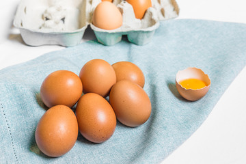 Fresh chicken eggs against white and blue background