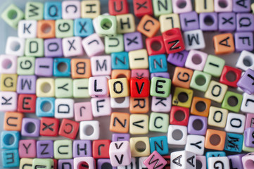 Close up shot of the colorful alphabet beads selective focus on beads forming word LOVE.