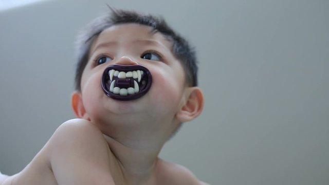 asian baby kid sucking nipple pacifier fancy vampire teeth dracula devil in halloween celebration party