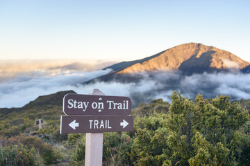 Trail in mountains above the clouds at sunset or sunrise
