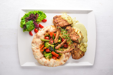 Veal steak on the bone. Grilled vegetables. Top view. Free space for text. On a wooden background.