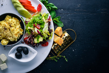 English breakfast. Fried eggs, salmon, olives, nuts, vegetables and dried fruit. Top view. Free space for text. On a wooden background.