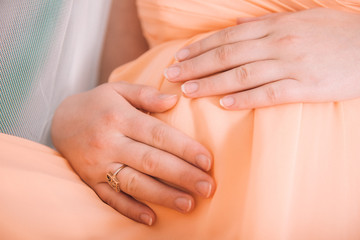 Pregnant girl hugging her belly