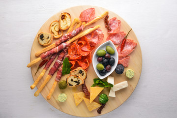 Fototapeta na wymiar Cold snacks. Chopped sausage, bacon, olives, olives. Top view. Wooden background. Free space for text.