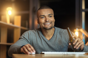 Positive delighted man being at work in the evening