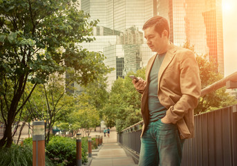 Businessman. Happiness businessman with phone around skyscrapers