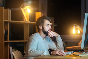 Concentrated brunette touching his chin