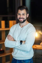 Positive delighted bearded man crossing arms