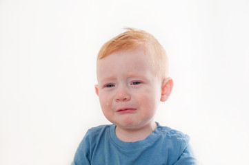 Offended and upset the baby cries on white background
