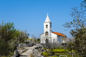 Fototapeta na wymiar Small white church on a sunny day with blue sky