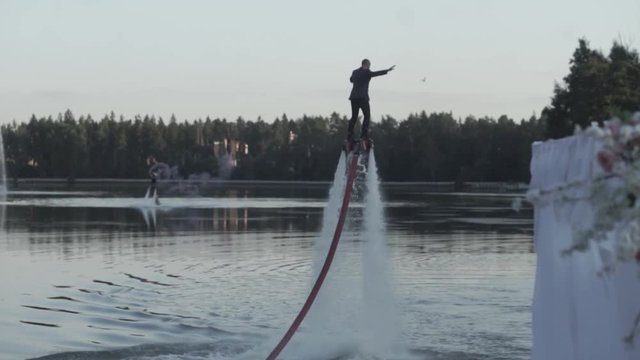 Man on flyboard. Man in a business suit wins the water on a flyboard