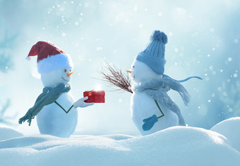 Merry christmas and happy new year greeting card .Two cheerful snowmen  standing in winter christmas landscape.