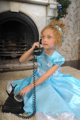 little girl in blue dress with vintage phone talking
