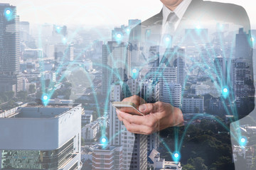 Fototapeta na wymiar Double exposure of businessman hand hold smartphone, mobile, pin node networking with cityscape and world map as business, technology, telecommunication, communication and innovation concept.