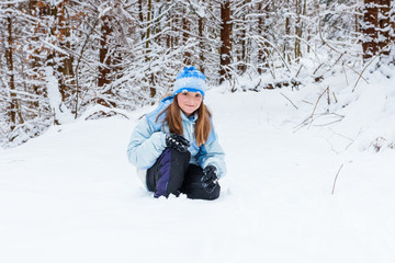 Fototapeta na wymiar girl enjoying day playing in winter forest