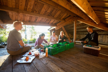 Obraz na płótnie Canvas Multiethnic Friends Preparing Meal In Shed At Forest
