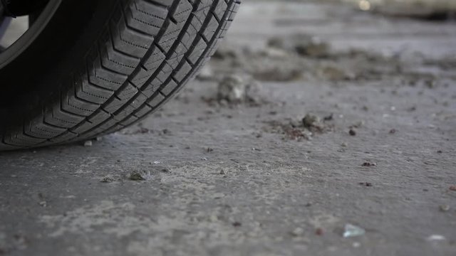 Close up view of standard vehicle tire on the muddy ground.  Panning effect.